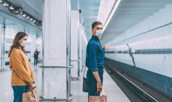 passengers in protective masks waiting for the metro train . coronavirus in the city