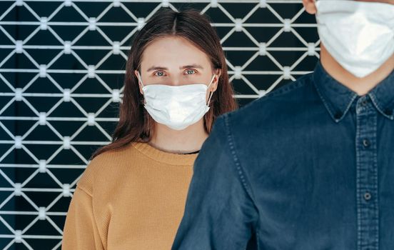 woman and a man in protective masks standing at a distance. concept of health protection