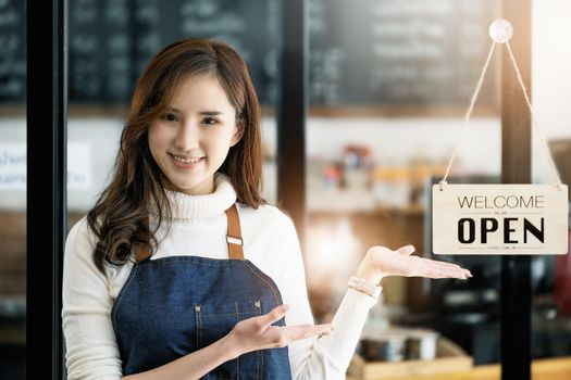 Startup stores, small business owners Standing to display a sign at the reception for customers who will come to use the service in the shop after the coronavirus situation began to unfold