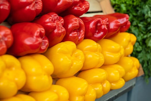 Close up of fresh peppers yellow and red lying on shelf in supermarket. Market and trade concept