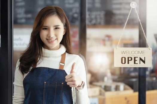 Startup stores, small business owners Standing to display a sign at the reception for customers who will come to use the service in the shop after the coronavirus situation began to unfold