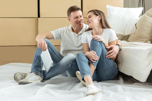 happy couple sitting near boxes in a new apartment. photo with copy-space