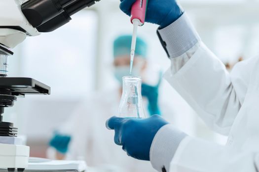 close up. scientist examining a liquid in a laboratory flask. science and health.