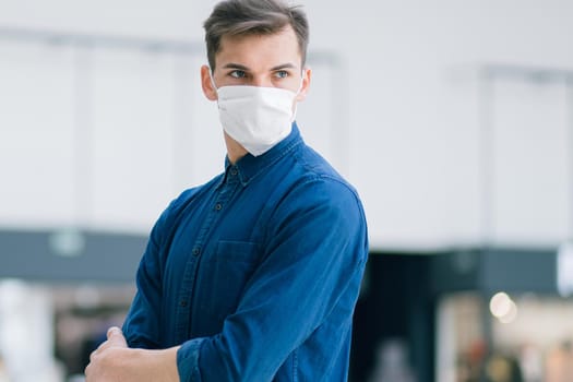 young man in a protective mask on a city street. photo with a copy of the space