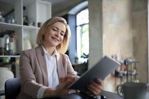 Beautiful business woman on the workplace using a digital tablet