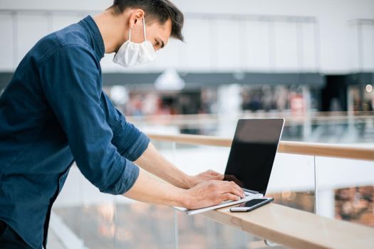 close up. a young man in a protective mask using a laptop. photo with a copy of the space