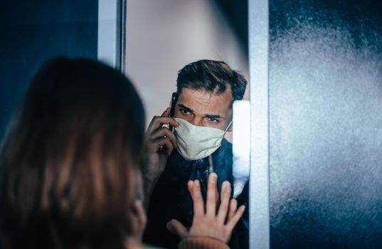 close up. young man talking to his girlfriend through the glass. photo with a copy-space