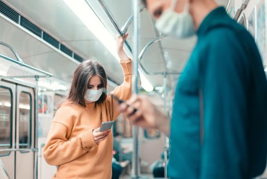 people with smartphones standing in a subway car. coronavirus in the city