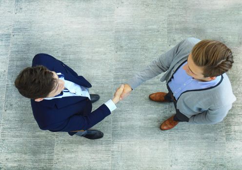 Top view of a two businessman shaking hands. Welcome to business.