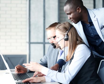 Phone operator working at call centre office helping hiss colleague