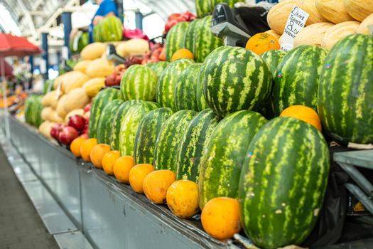 Ripe delicious watermelons with melons for sale on the counter at local wholesale market in the summer. Watermelons and melons season concept.