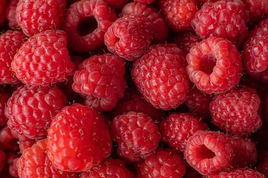 Macro shot of fresh delicious heap of succulent and juicy raspberries from above.