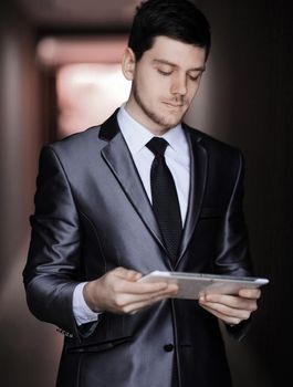 close up. portrait of elegant businessman with digital tablet on office background.