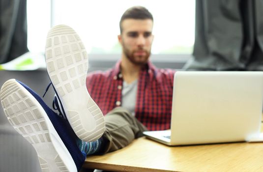 Young smart people are using gadgets while working hard in the modern office. Young man working on his laptop.