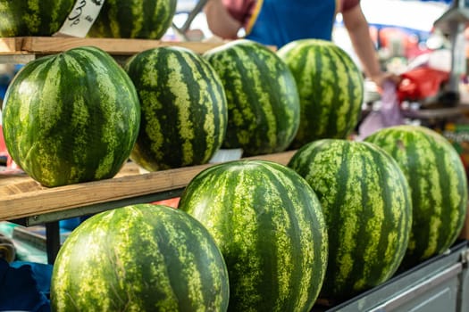 Close up of group of fresh green watermelons and yellow sweet melons ready for sale in organic farm. Fresh fruits concept