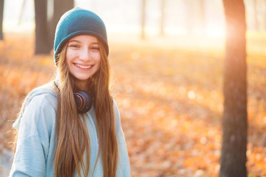 Nice girl with headphones in autumnal nature