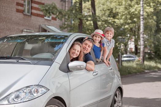 happy family with children sitting in a family car. travel together