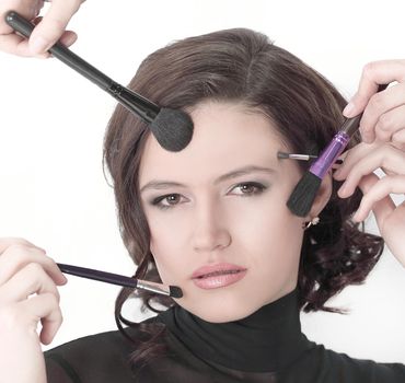 beautiful young woman holding make-up brushes.