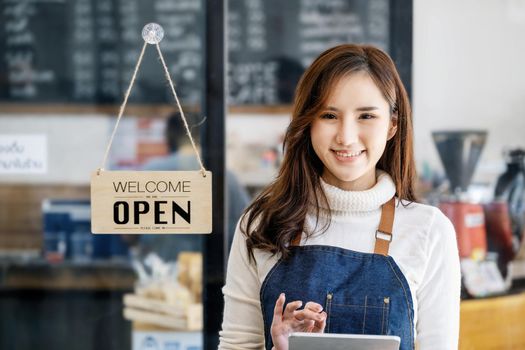 Startup stores, small business owners Standing to display a sign at the reception for customers who will come to use the service in the shop after the coronavirus situation began to unfold