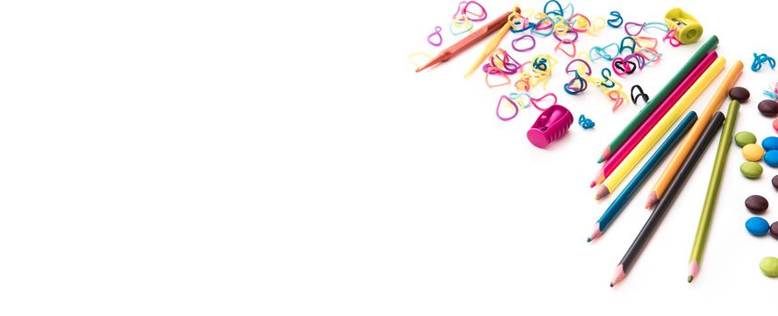 white backgrounnd with colourful kid 's sweets and stationery with copyspace. Childhood concept.