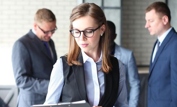 business woman with her staff, people group in background at modern bright office indoors