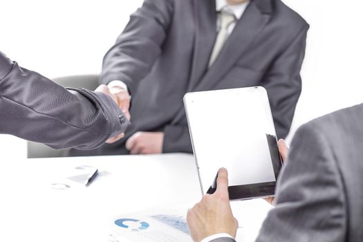 close up.businessman with a digital tablet on the background of a handshake of business partners