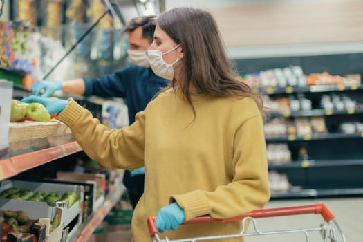 close up. young woman in a protective mask buys apples