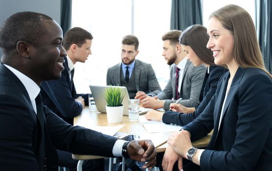 Image of two young business people interacting at meeting in office