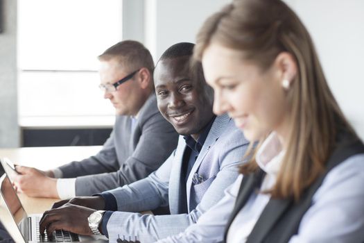 Portrait of smiling African American business man with executives working in background