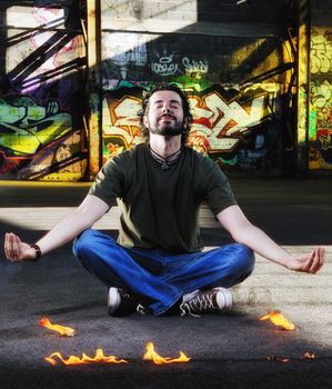 young happy man in urban enviroment practicing and meditating yoga in lotus position 