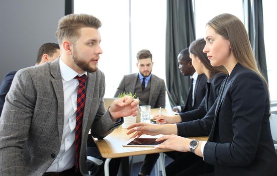 Image of two young business people interacting at meeting in office
