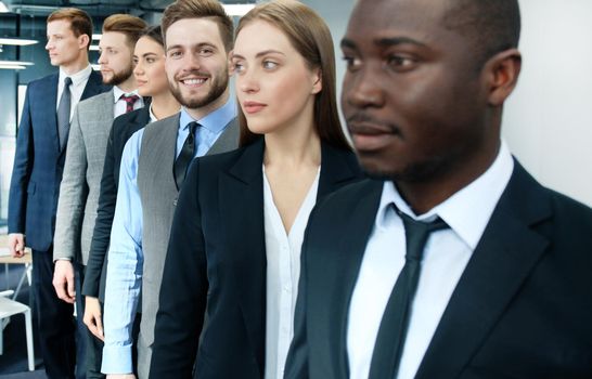 Happy smiling business team standing in a row at office.