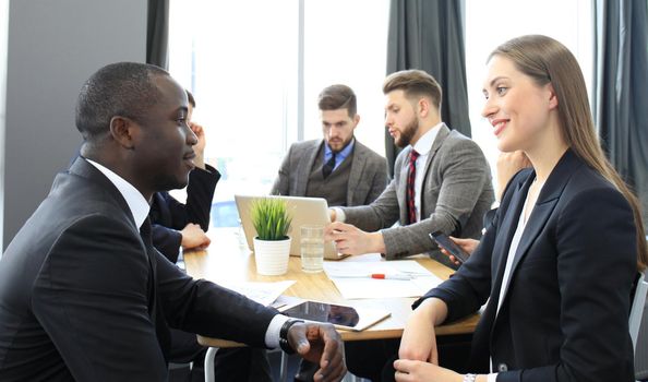 Image of two young business people interacting at meeting in office