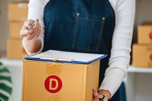 Work from home. Happy Woman Selling Products Online Startup Small Business Owners Hand the customer a pen to sign to receive the customer's package