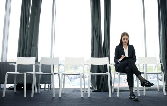 Young woman waiting for job interview indoors.