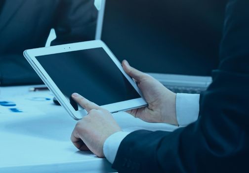 Close-up of a modern business team using tablet computer to work