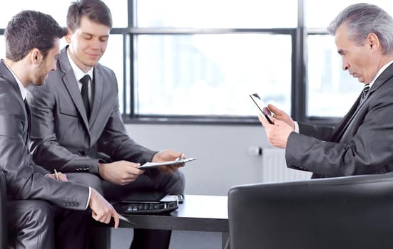 boss with a clipboard , sitting in an office.