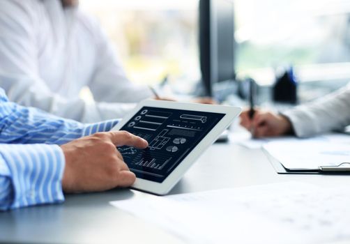 Business person analyzing financial statistics displayed on the tablet screen