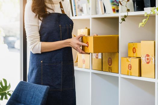 Work from home. happy women selling products online Startup small business owners are picking up parcel boxes to pack customer orders and prepare them for postage