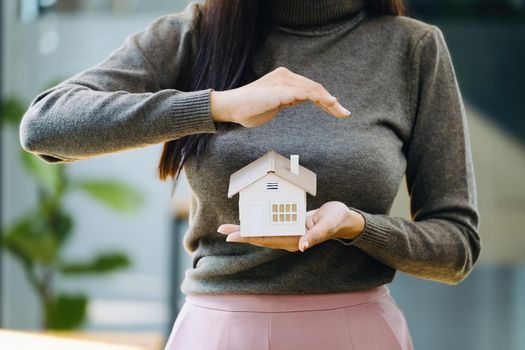 Real estate agent gesturing to protect homes, housing insurance concept