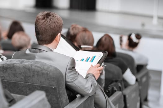 rear view. businessman sitting in the hall at a business presentation. business and education