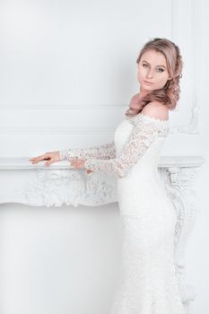 beautiful young woman in wedding dress standing in Bridal salon . holidays and events