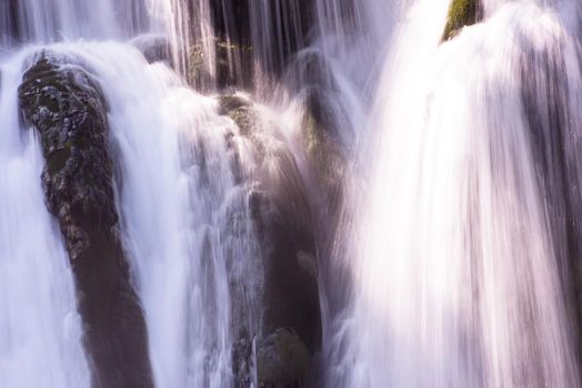 Amazing nature landscape, beautiful waterfall with sunlight in deep summer forest