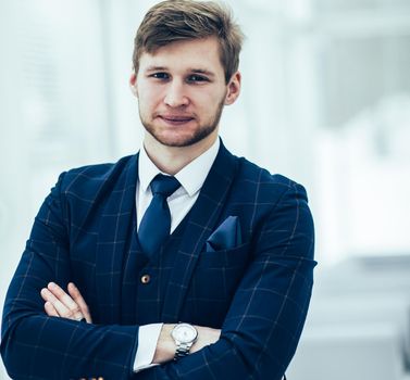 newcomer businessman in a business suit stands near the window, hands folded in front of him .the photo has a empty space for your text