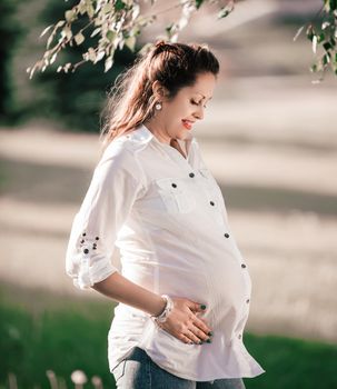 happy pregnant woman looking at her belly. the concept of motherhood