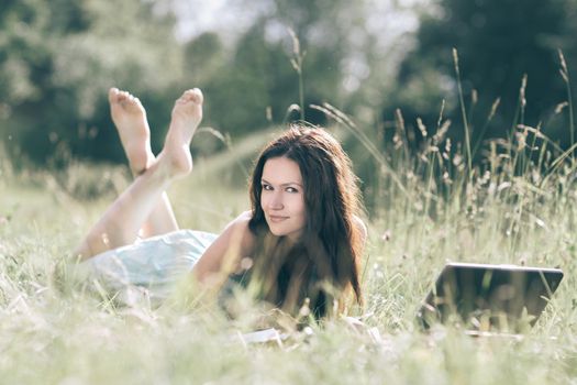 modern cute girl relaxarea on the fresh grass. people and technology