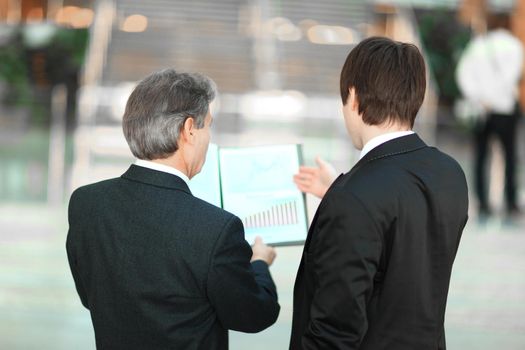 rear view.closeup of business partners discussing financial documents.business concept