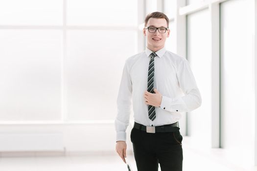 portrait of a young company employee standing in the office. photo with copy space