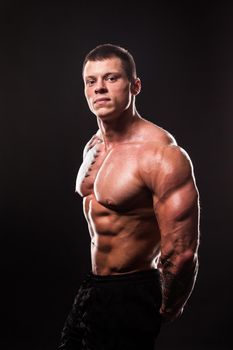 muscular male bodybuilder looking at the camera.isolated on black background