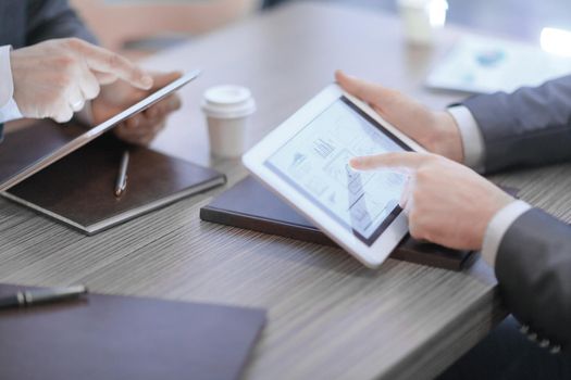 close up.two members constitute financial otches using digital tablet.